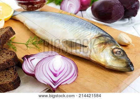 Whole salted herring with boiled beet red onion garlic lemon dill rye bread. Ingredients for sandwich salad.