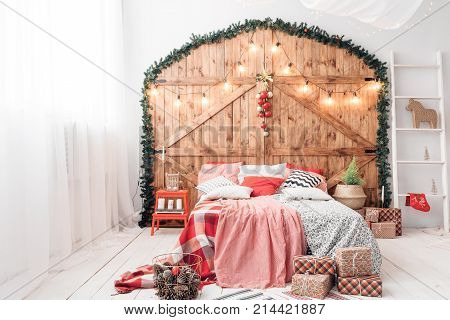 Xmas in morning bedroom. Double bed In christmas Interior on wood wall background.