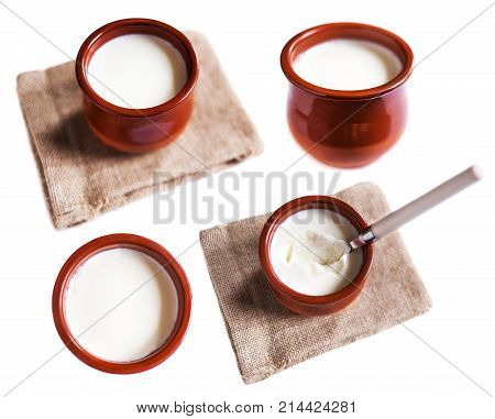 Yogurt cream or Cottage cheese curd in clay pot isolated on a white background. Traditional Cuajada sour cream