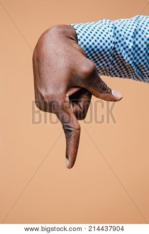 Black male hand point finger. Hand gestures - man pointing on virtual object with forefinger, isolated on brown background
