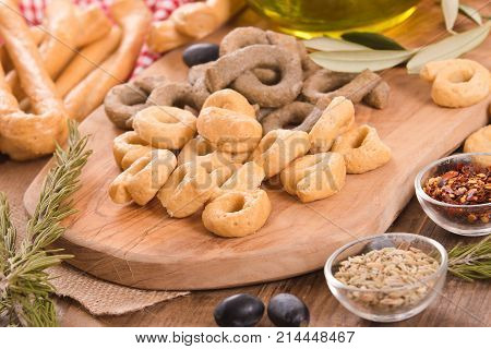 Italian taralli with spices on cutting board.