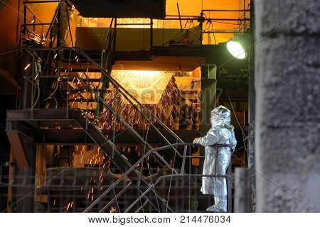 Molten Metal Pouring Out Of Furnace and Workers