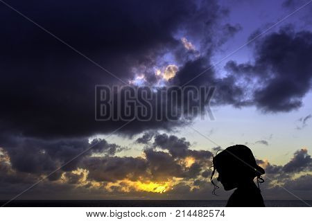 Silhouette of a young girl with sunrise over the ocean in background - Los Cocoteros, Lanzarote, Canary Islands, Spain