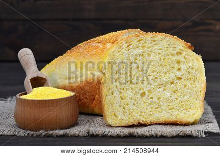 Cornbread and corn flour on wooden background