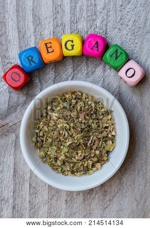 Oregano In Bowl With Letter Cube On Wooden Background
