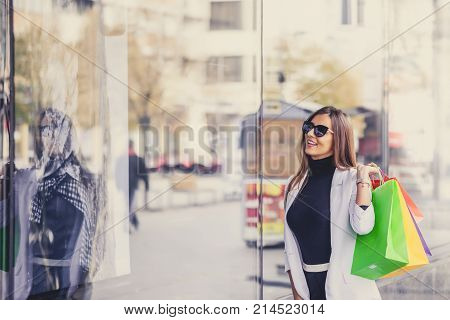 Smiling Woman Pointing At The Shop Window Before Entering Stor