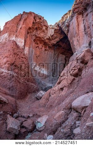 Entrance to a red rocky layered stripe cave in Palo Duro Canyon national park in Texas