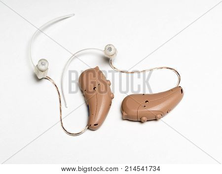 Macro close up of a matched pair of tiny modern hearing aid on white isolated background