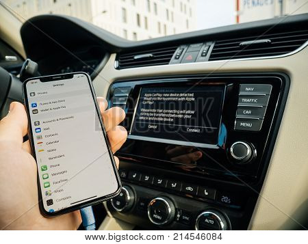 FRANKFURT GERMANY - NOV 4 2017: Man connecting his new iPhone X 10 to the navigation system of the car with CarPlay - message on GPS - new device detected