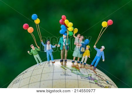 miniature people figure happy family holding balloons standing on united states of america map on globe as world climate change or happy family concept.