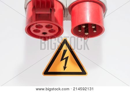 Red and white three-phase plug and socket with warning sign isolated
