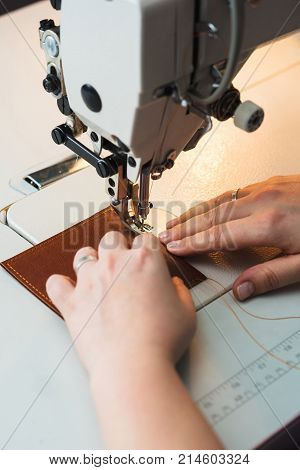Closeup of sewing machine working part with leather