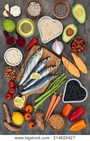 Super food for a healthy heart concept with fresh salmon, fruit, vegetables, nuts, beetroot smoothie, herbs and spices. Health food high in omega 3, antioxidants, anthocyanins and vitamins.