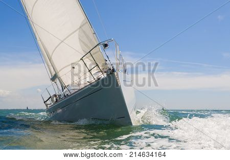 Close up of sailing boat, sail boat or yacht at sea on summer day with blue sky