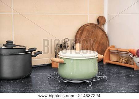 Stewpan and other kitchen utensils on table in kitchen