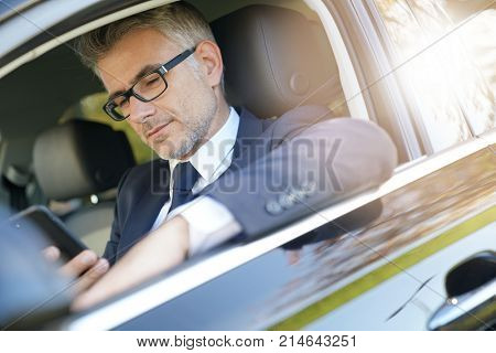 Taxi driver talking on phone while waiting for client