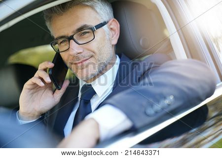 Taxi driver talking on phone while waiting for client