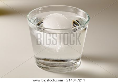 Physics. Ice cube floating in a glass of water. 