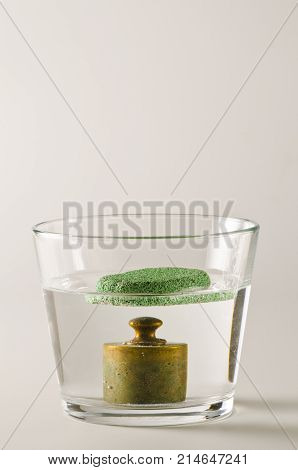 Physics. A pumice floats in water and a antique weight sinks. 