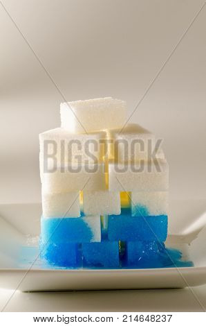 Physics. Capillary action. Dyed water is going up sugar cube tower.