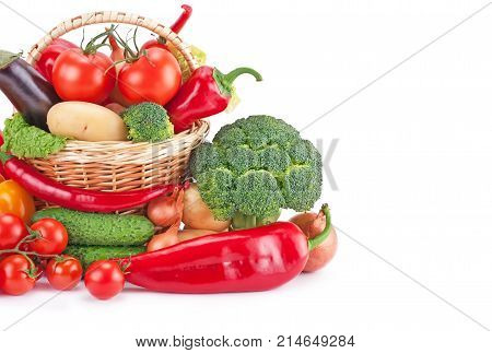 fresh and ripe vegetables arranged in a basket isolated on white