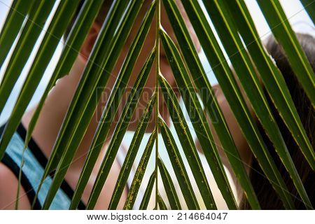 Romantic portrait of attractive couple in love hugging on the beach at the sunset on tropic island. Holding in their hands glasses of champagne. Against the backdrop of the sea and setting sun.