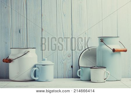 Enamelware on the kitchen table over blue wooden wall