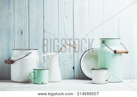 Enamelware on the kitchen table over blue wooden wall