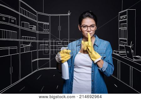 Top secret. Pleasant concentretaed woman clening the study while lookign at you and keeping secret