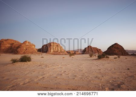Valley in the Sinai desert with mountains and sun.