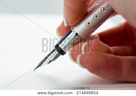 hand with fountain pen at signature