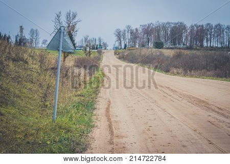 Sharp Turn With Warning Sign On A Gravel Road.
