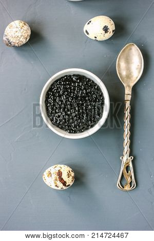 Top view of black caviar in white ceramic bowl