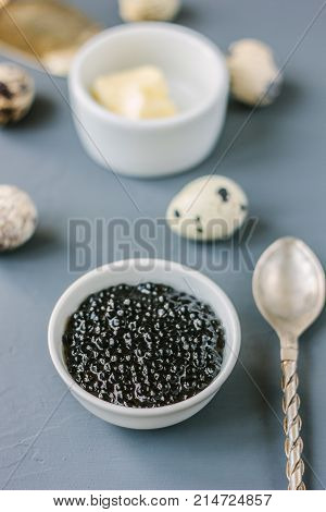A black caviar in a white ceramic bowl.