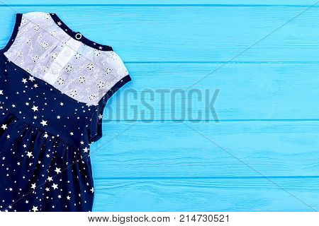 Baby girl apparel, copy space. Baby girls short dress embroidered printing. Infant girl summer dress, top view.