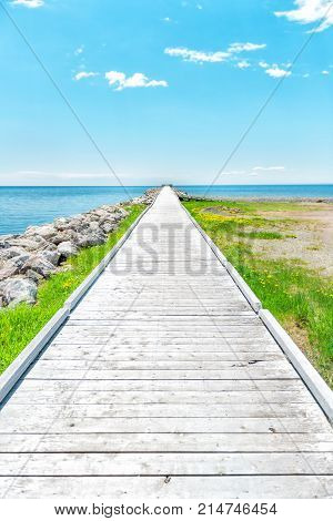Empty Long Wooden Boardwalk With Nobody On Pier Dock Quay With Gulf Of Saint Lawrence River In Gaspe