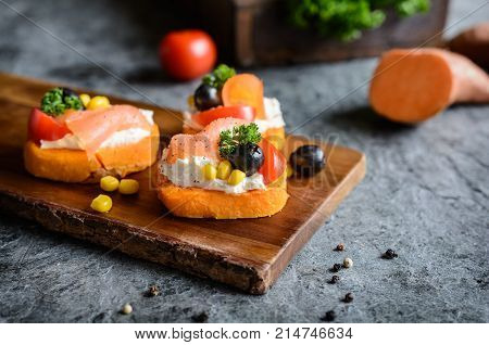 Baked Sweet potato slices topped with cream cheese smoked salmon olives and corn