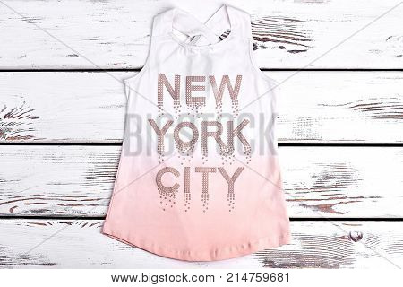 Beautiful strass print t-shirt for girls. Sleeveless cotton girls t-shirt with inscription new york city written by strasses on old wooden background. Fashion design t-shirt for girls.