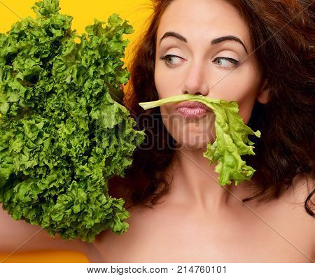 Healthy eating concept. Dieting. Woman hold lettuce looking at the corner on yellow  background