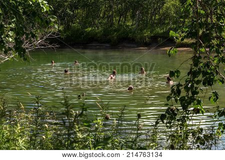 Kamchatka Peninsula, Russia - August 13, 2016: Tourists are bathing in Khodutkinskiye hot springs at the foot of the volcano Priemysh. South Kamchatka Nature Park.