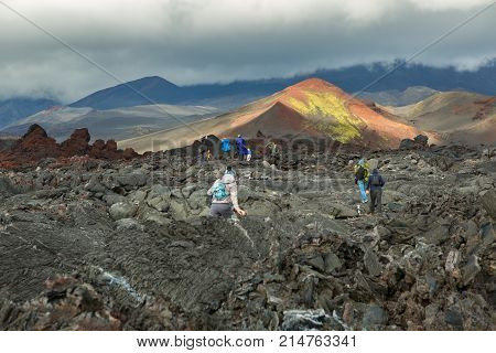 Kamchatka Peninsula, Russia - August 21, 2016: Group of tourists walks on the Lava field at the Tolbachik volcano, after eruption in 2012