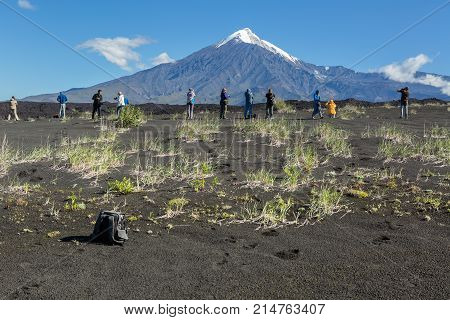 Kamchatka Peninsula, Russia - August 22, 2016: Group of tourists photographing Tolbachik Volcano, Klyuchevskaya Group of Volcanoes in Kamchatka.