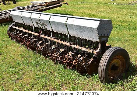 An old metal seed box  with rubber tires grain drill for planting small grain such as oats, beans and wheat.