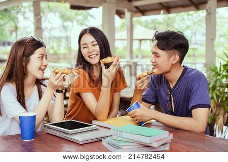 Students asian group together eating pizza in breaking time early next study class having fun and enjoy party italian food slice with cheese delicious at university outdoor