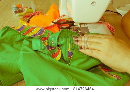 Woman hand on sewing machine.Dressmaker work on the sewing machine. Hobby sewing fabric as a small business concept. Dressmaker woman working with sewing machine