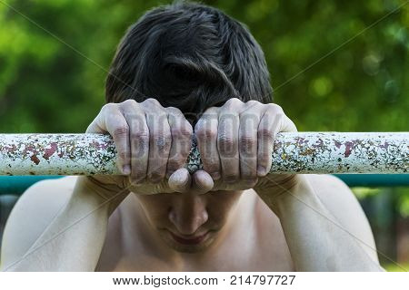 young man holding hands on the horizontal bar