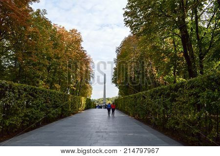 People walk along the green avenue of bushes and trees. Kiev. Ukraine.