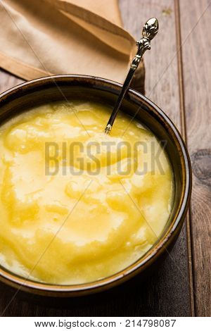Desi Ghee or clarified butter in glass or Copper container or ceramic jar with spoon, selective focus