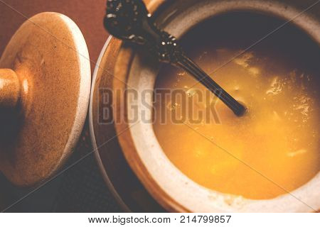 Desi Ghee or clarified butter in glass or Copper container or ceramic jar with spoon, selective focus