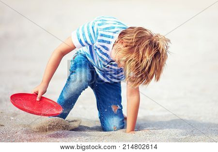 Young Boy With Flying Disk In Motion, Playing Leisure Activity Games On The Sandy Beach